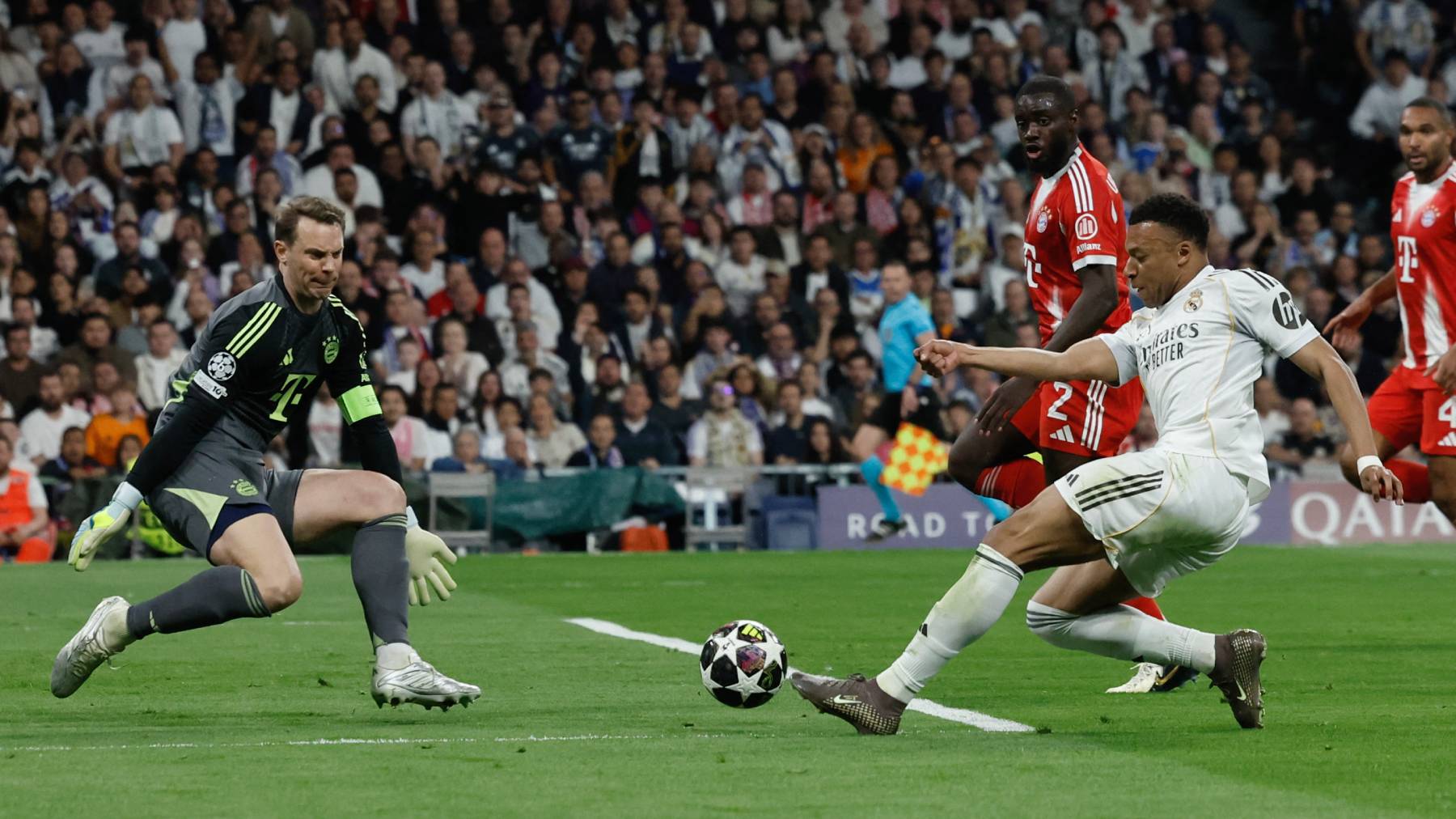 Real Madrid's French forward #10 Kylian Mbappe (R) shoots but fails to score past Bayern Munich's German goalkeeper #01 Manuel Neuer during the UEFA Champions League quarter final first leg football match between Real Madrid CF and FC Bayern Munich at Santiago Bernabeu Stadium in Madrid on April 7, 2026.