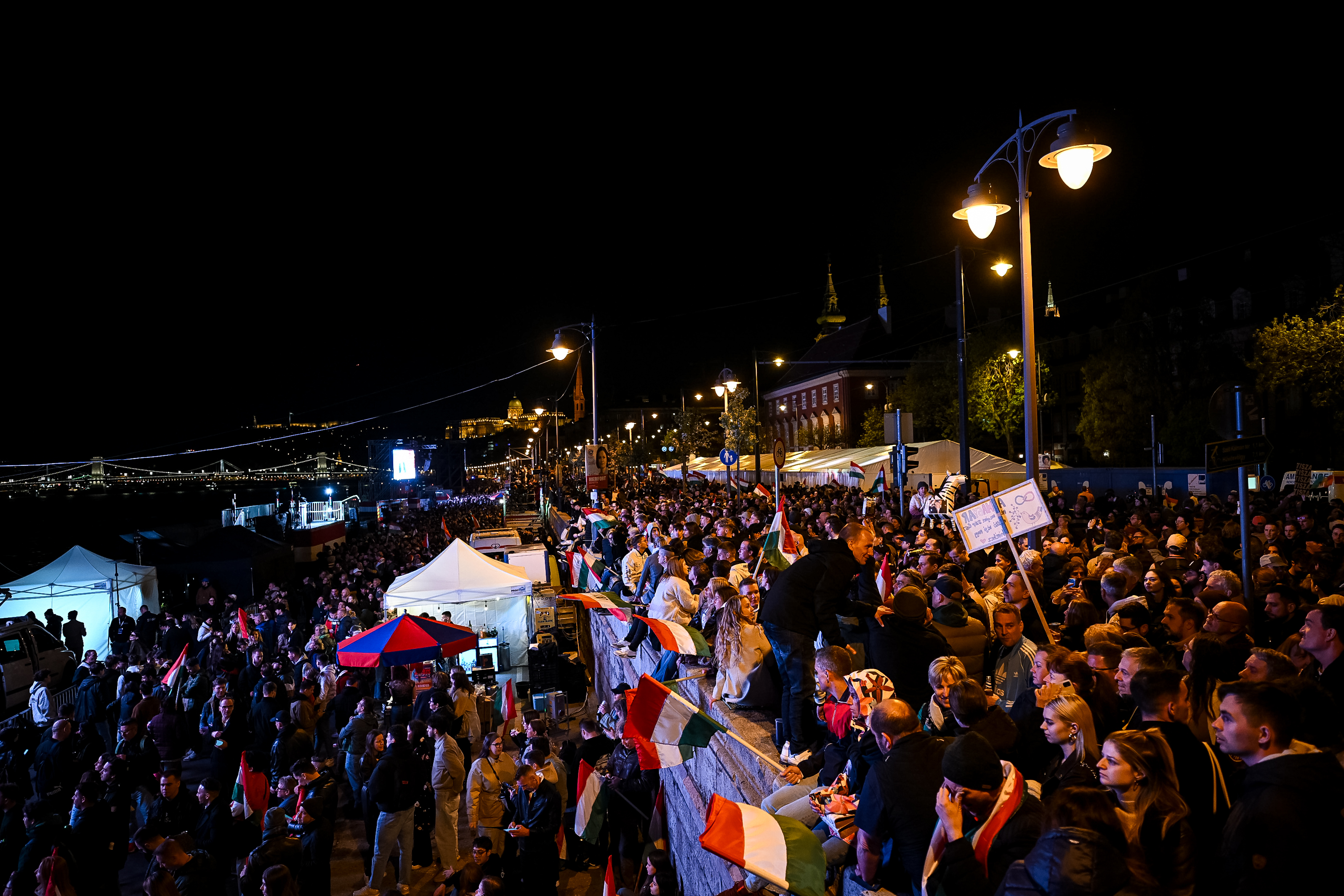 Kékbe borult ország és lámpaoszlopról fideszes plakátot leszedő férfi a rakparton 1