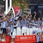 Real Sociedad's players celebrate with the trophy at the end the Copa del Rey (King's Cup) final football match between Club Atletico de Madrid and Real Sociedad at La Cartuja stadium in Seville on April 18, 2026. Real Sociedad won Atletico Madrid 4-3 on penalties.