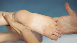 Egy talp és az azt masszírozó kezek