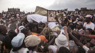 People carry a body wrapped in a sheet after taking it out from a crypt, as they take part in a funerary tradition called the Famadihana in the village of Ambohijafy, a few kilometres from Antananarivo, on September 23, 2017. During the Famadihana, which can be translated as "turning of the bones", several crypts are opened and people take the bodies of their ancestors from the family crypts and rewrap them in fresh cloth, then dance with the corpses in their arms at the pace of traditional Malagasy band's music. The Famadihana is a pillar in the Malagasy ancestor's worship and is celebrated each three, five or seven years. (Photo by )