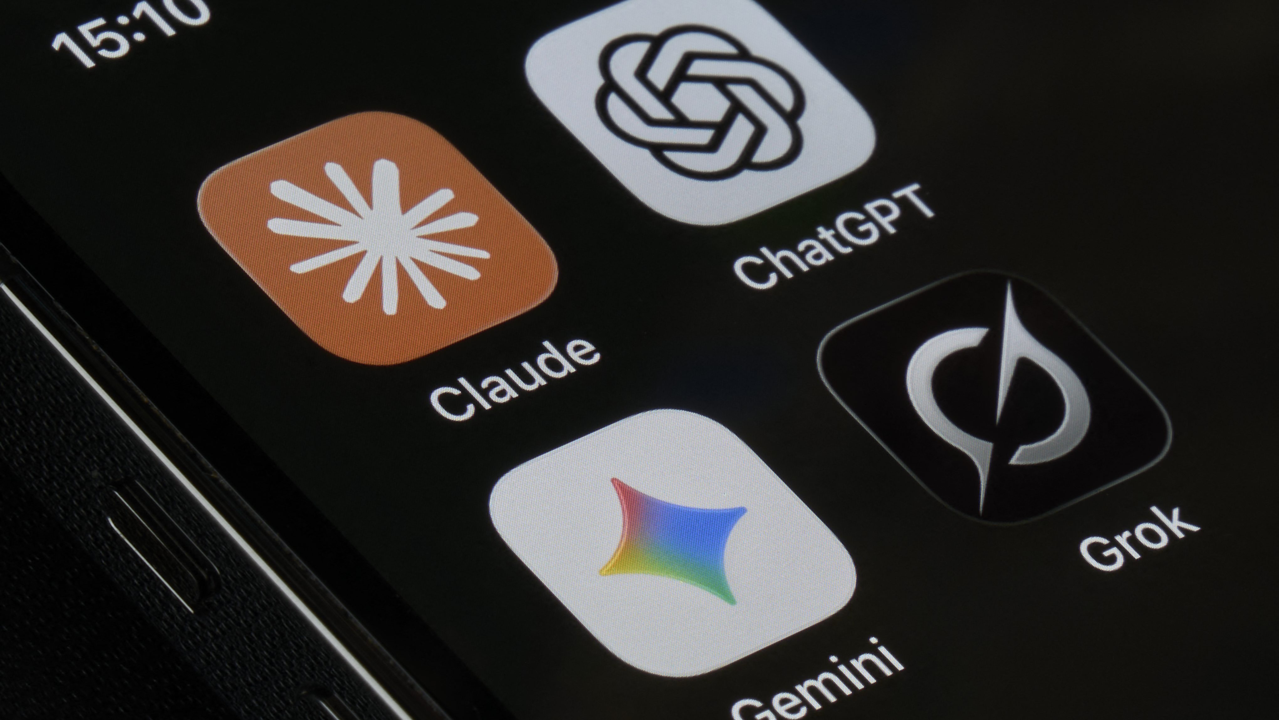 An iPhone screen photographed at close range displays four AI assistant application icons arranged in a two-by-two grid in San Ferdinando di Puglia, Italy, on May 17, 2026. The visible applications include Claude by Anthropic, ChatGPT by OpenAI, Gemini by Google, and Grok by xAI. The phone clock reads 15:10. The image provides a visual overview of leading consumer-facing generative AI chatbot applications available on mobile platforms as of May 2026. (Photo Illustration by Matteo Della Torre/NurPhoto) (Photo by Matteo Della Torre / NurPhoto via AFP)
