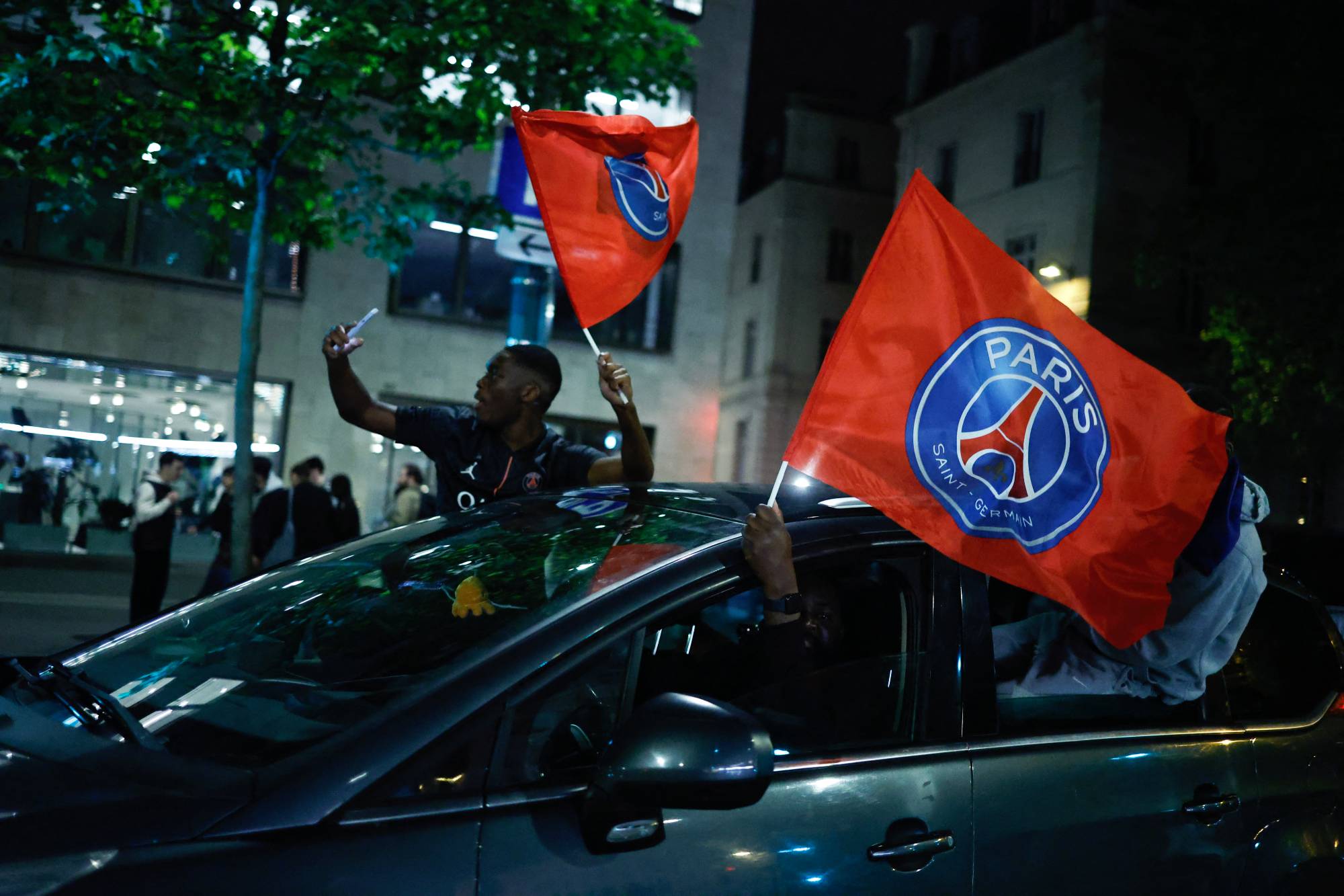 Paris Saint-Germain (PSG) supporters celebrate their team's progression to the Final of the UEFA Champions League near the Champs-Elysees after their second-leg semi-final football match against Bayern Munich, in Paris, on May 6, 2026. The holders set up a Champions League final against Arsenal after a 1-1 second-leg draw at Bayern Munich secured a 6-5 aggregate victory.