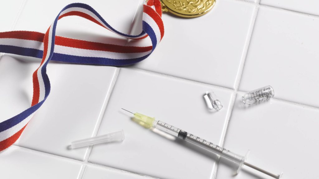 . Medal and syringe on tiled floor - stock photo
