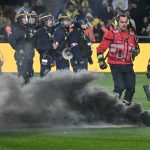 Fire Safety personel run to catch a smoke flare during the French L1 football match between FC Nantes and Toulouse FC at the Stade de la Beaujoire–Louis Fonteneau in Nantes, western France, on May 17, 2026.
