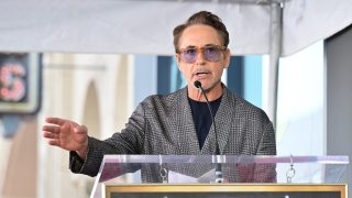 Robert Downey Jr. mikrofonba beszél egy pódium mögött állva