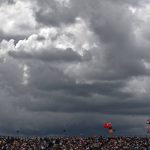 Fans sit in the stands as storm clouds gather in the sky above, ahead of the Formula One British Grand Prix at the Silverstone motor racing circuit in Silverstone, central England on July 3, 2022.