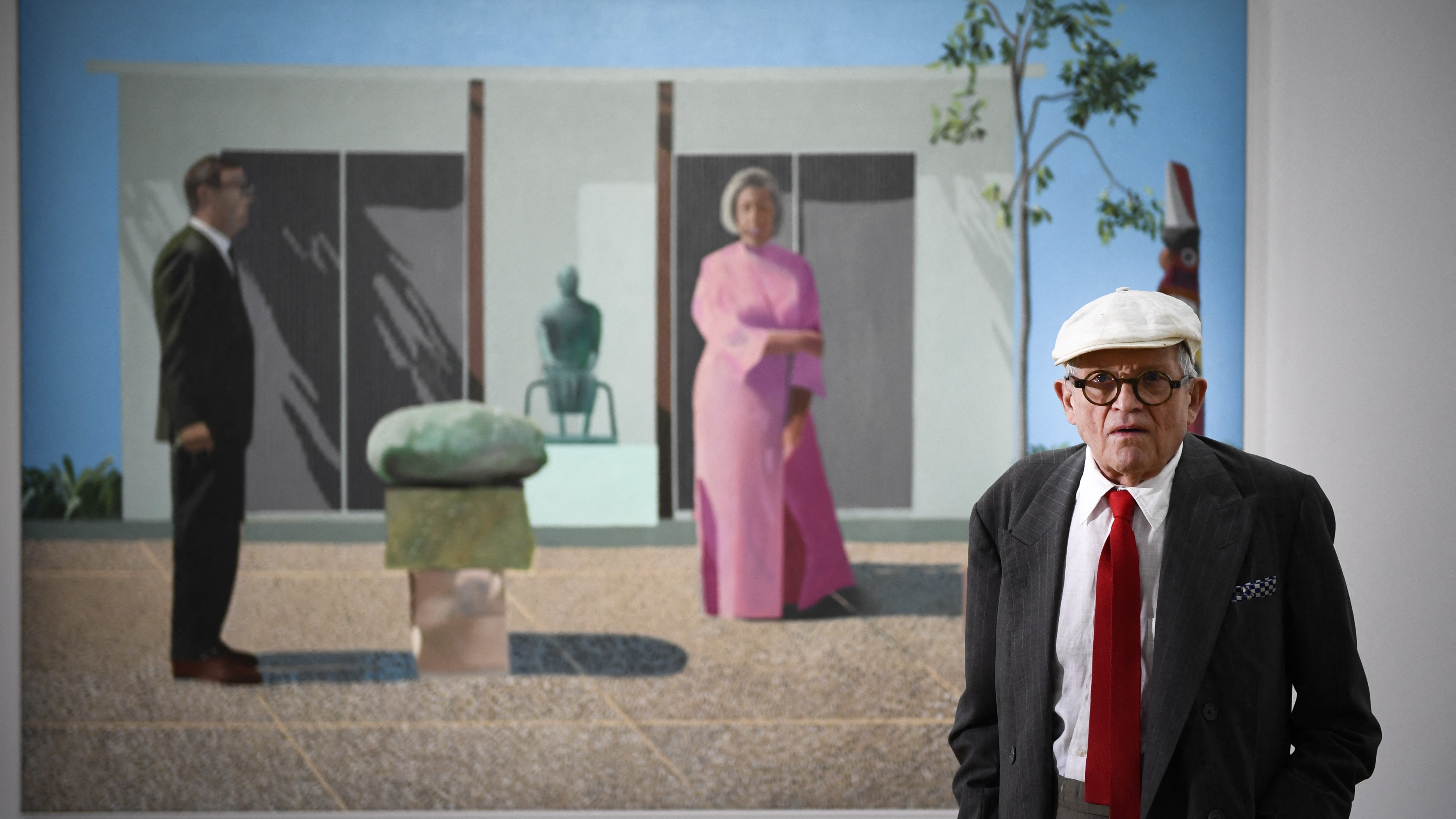 (FILES) British artist David Hockney poses in front of his painting "Fred and Marcia Weisman" during a photo session at the Pompidou Centre in Paris, on June 16, 2017. British artist David Hockney, considered one of the most influential and defining figures in contemporary art, whose paintings captured the world in brilliant colour, has died aged 88, his public relations agent announced on June 12, 2026. (Photo by Martin BUREAU / AFP) / RESTRICTED TO EDITORIAL USE - MANDATORY MENTION OF THE ARTIST UPON PUBLICATION - TO ILLUSTRATE THE EVENT AS SPECIFIED IN THE CAPTION