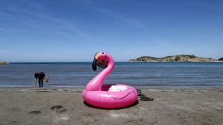 Protesters gather in Portonovo in Zvernec near Vlora, Albania, on June 6, 2026, during ongoing demonstrations against a proposed luxury tourism development project linked to Jared Kushner. Participants carry banners, flags, and symbolic flamingo imagery. (Photo by Vlasov Sulaj/NurPhoto) (Photo by Vlasov Sulaj / NurPhoto via AFP)