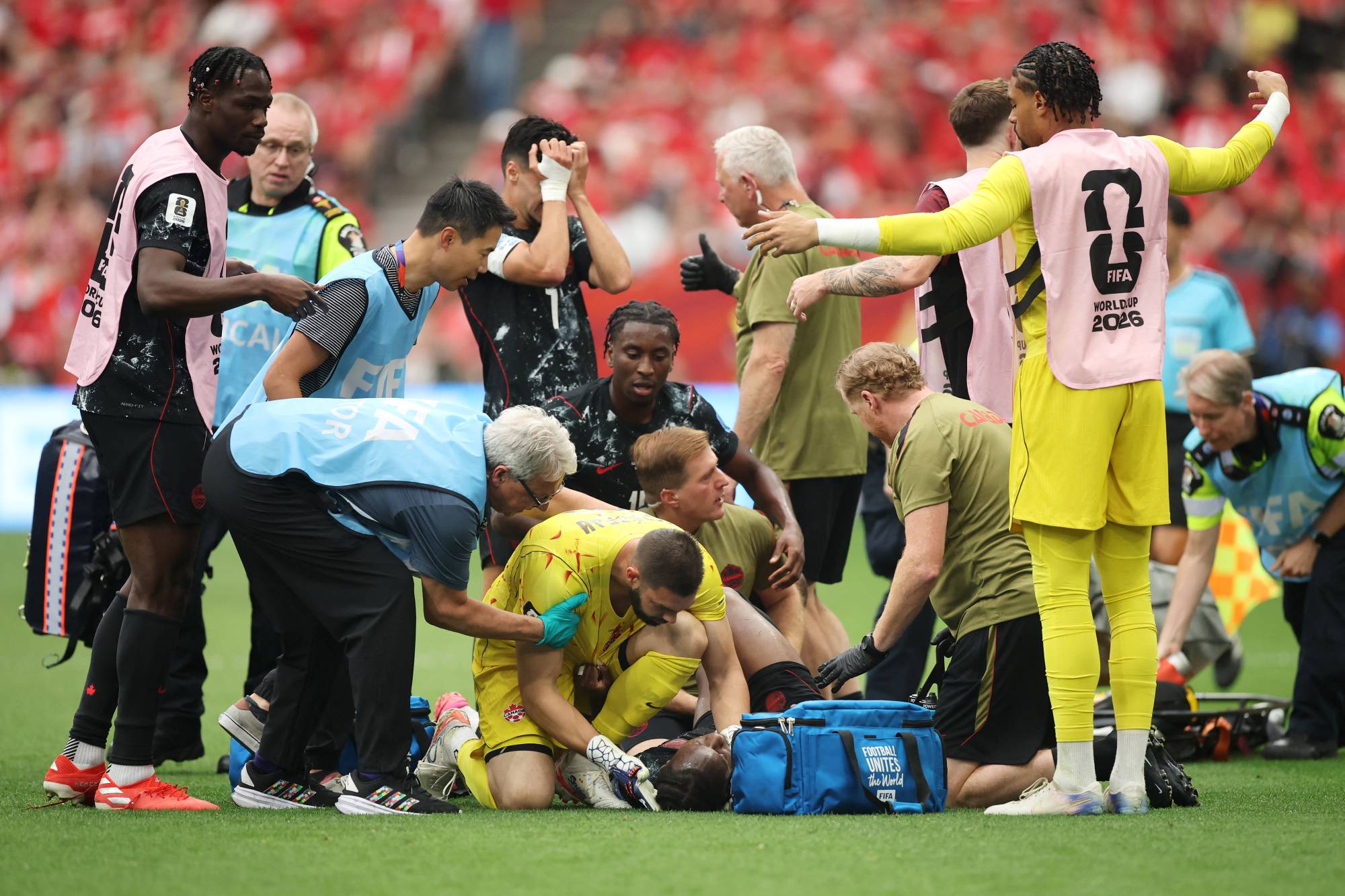 VANCOUVER, BRITISH COLUMBIA - JUNE 18: Ismael Kone #8 of Canada is consoled by Maxime Crepeau #16 of Canada as he receives the medical attention after being fouled by Assim Madibo #23 of Qatar during the FIFA World Cup 2026 Group B match between Canada and Qatar at BC Place Vancouver on June 18, 2026 in Vancouver, British Columbia. Alex Grimm/Getty Images/AFP