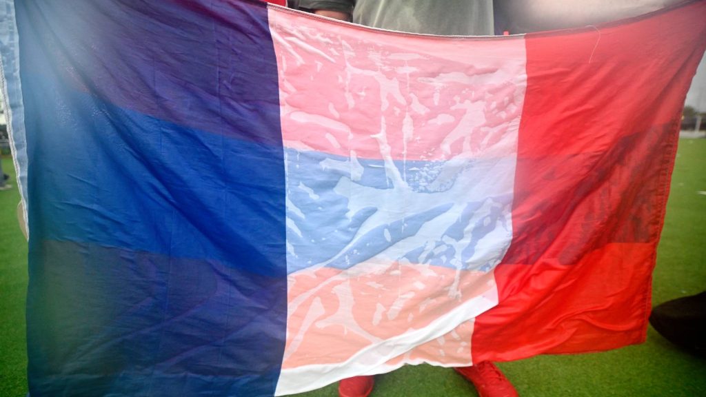 A drenched French flag is held by fans watching the Group E match between France and Iraq at a watch party at Stateside Live! in Philadelphia, Pennsylvania, United States, on June 22, 2026. Attendees are warned to find shelter due to a lightning and thunderstorm, which delays the match at halftime at the nearby Philadelphia Stadium. (Photo by Bastiaan Slabbers/NurPhoto)