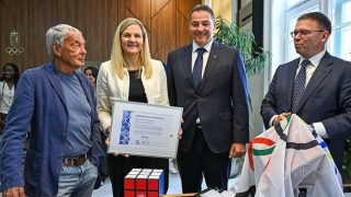 Rubik Ernő Kossuth-díjas feltaláló, játéktervező, szobrász, építész, formatervező, belsőépítész (b), Gyulay Zsolt, a Magyar Olimpiai Bizottság (MOB) elnöke (b3) és Fürjes Balázs, a Nemzetközi Olimpiai Bizottság (NOB) magyar tagja (b4) Rubik-kockát ajándékoz Kirsty Coventrynek, a NOB elnökének (b2) a MOB székházában 2026. június 12-én.