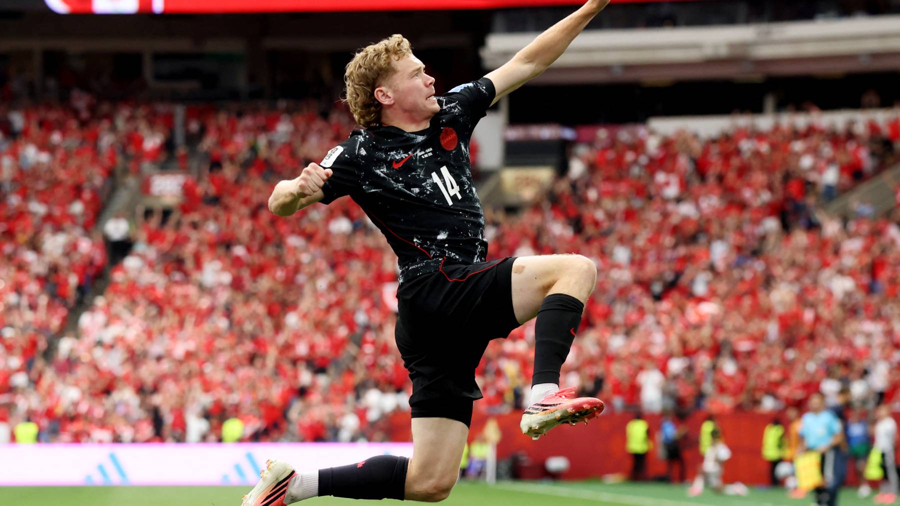 VANCOUVER, BRITISH COLUMBIA - JUNE 18: Jacob Shaffelburg #14 of Canada celebrates the team's fifth goal, an own goal by Mohamed Manai #26 of Qatar (not pictured), during the FIFA World Cup 2026 Group B match between Canada and Qatar at BC Place Vancouver on June 18, 2026 in Vancouver, British Columbia. Alex Grimm/Getty Images/AFP