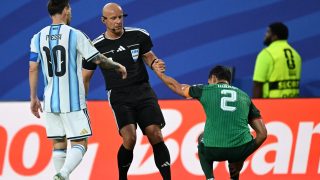 Polish referee Szymon Marciniak lifts Algeria's defender #02 Aissa Mandi as he reacts in pain next to Argentina's forward #10 Lionel Messi during the 2026 World Cup Group J football match between Argentina and Algeria at the Kansas City Stadium in Kansas City on June 16, 2026.