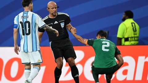 Polish referee Szymon Marciniak lifts Algeria's defender #02 Aissa Mandi as he reacts in pain next to Argentina's forward #10 Lionel Messi during the 2026 World Cup Group J football match between Argentina and Algeria at the Kansas City Stadium in Kansas City on June 16, 2026.