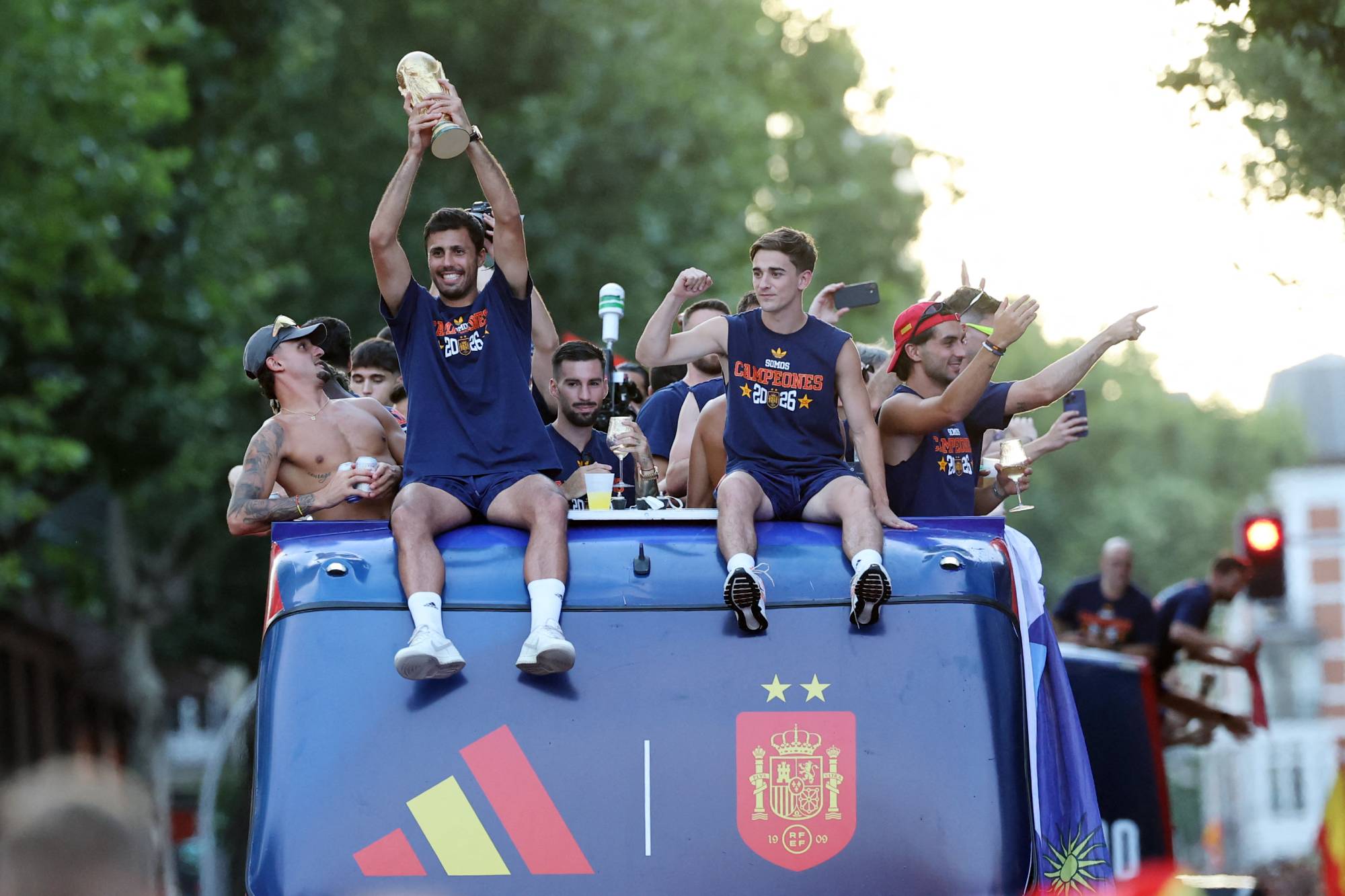 Spain's midfielder Rodri holds their trophy as Spain's players parade onboard an open-top bus through the streets of Madrid on July 20, 2026, one day after the national football team won their second World Cup title following a 1-0 victory against Argentina. Spain's World Cup winners come back home to a heroes' welcome in Madrid, where a million fans are expected to greet them after a night of raucous celebrations across the country.
