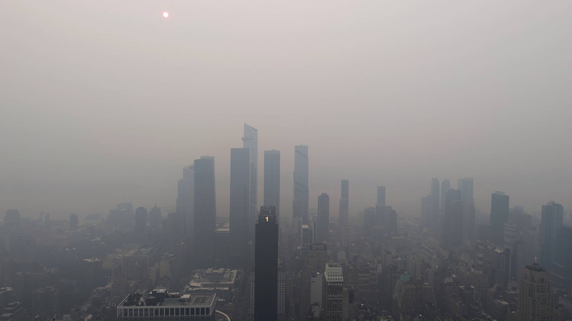 NEW YORK, NY - JULY 16: Smoke from wildfires in Canada shrouds the sun behind Hudson Yards, seen from the 86th-floor observation deck of the Empire State Building on July 16, 2026, in New York City. (Photo by Gary Hershorn/Getty Images)