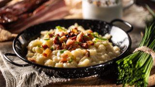 Halusky as traditional Slovak potato gnocchi with sheep cheese bryndza, fried bacon and chives.