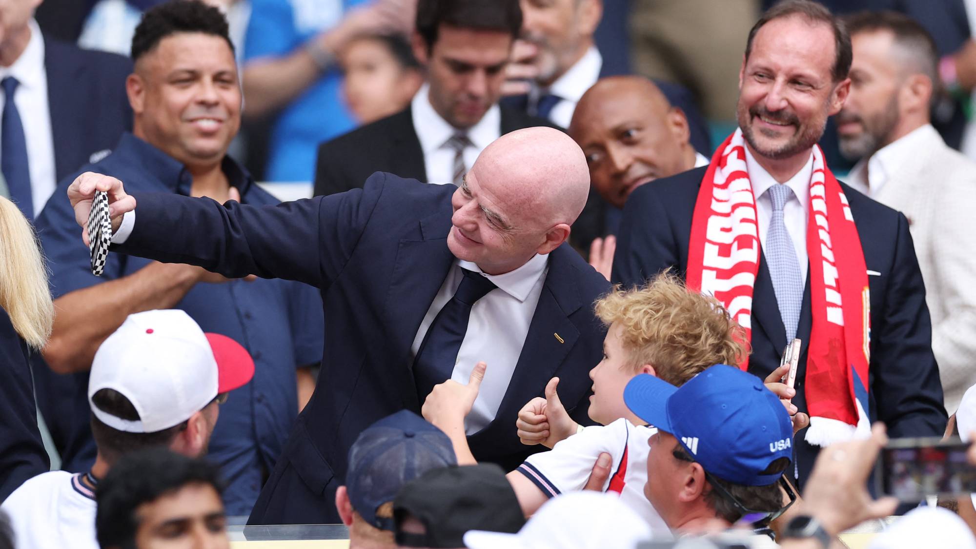 MIAMI GARDENS, FLORIDA - JULY 11: FIFA President Gianni Infantino takes a selfie while Crown Prince Haakon of Norway watches before the FIFA World Cup 2026 Quarter Final match between Norway and England at Miami Stadium on July 11, 2026 in Miami Gardens, Florida. Justin Setterfield/Getty Images/AFP