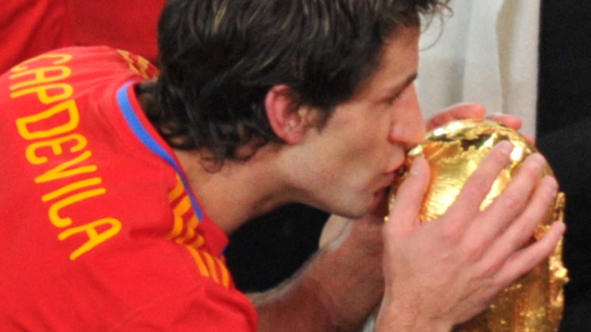 Spain's defender Joan Capdevila kisses the trophy during the award ceremony following their 2010 FIFA football World Cup match against the Netherlands on July 11, 2010 at Soccer City stadium in Soweto, suburban Johannesburg. Spain won the match 1-0. NO PUSH TO MOBILE / MOBILE USE SOLELY WITHIN EDITORIAL ARTICLE - AFP PHOTO / ROBERTO SCHMIDT