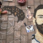 Kosovar artist Alkent Pozhegu works on a mosaic on the ground, made with grain and seeds, and depicting Argentina's forward #10 Lionel Messi (R) and Spain's forward #19 Lamine Yamal, in the town of Gjakova on July 16, 2026. Thousands of kilometres away from New York, where the Argentina and Spain football teams will compete for the World Cup title, in the western city of Gjakova, Alkent Pozhegu has made a mosaic depicting the two forward stars Lionel Messi and Lamine Yamal.