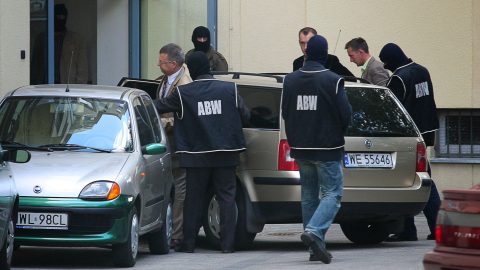 Former Polish Interior Minister Janusz Kaczmarek arrives enclosed by officers of the Polish Internal Security Agency (ABW) as he enters the prosecution building, 30 August 2007 in Warsaw, after he was detained with charge of obstructing an investigation, 30 August 2007. A former ally of Poland's ruling Kaczynski twins accused 28 August 2007 Prime Minister Jaroslaw Kaczynski of eavesdropping on him and another deputy prime minister in what he described as a "Polish Watergate". The accusation came as Poland's parliament prepares to decide on September 7 whether to dissolve itself to open the path to new elections. AFP PHOTO WOJTEK RADWANSKI (Photo by WOJTEK RADWANSKI / AFP)