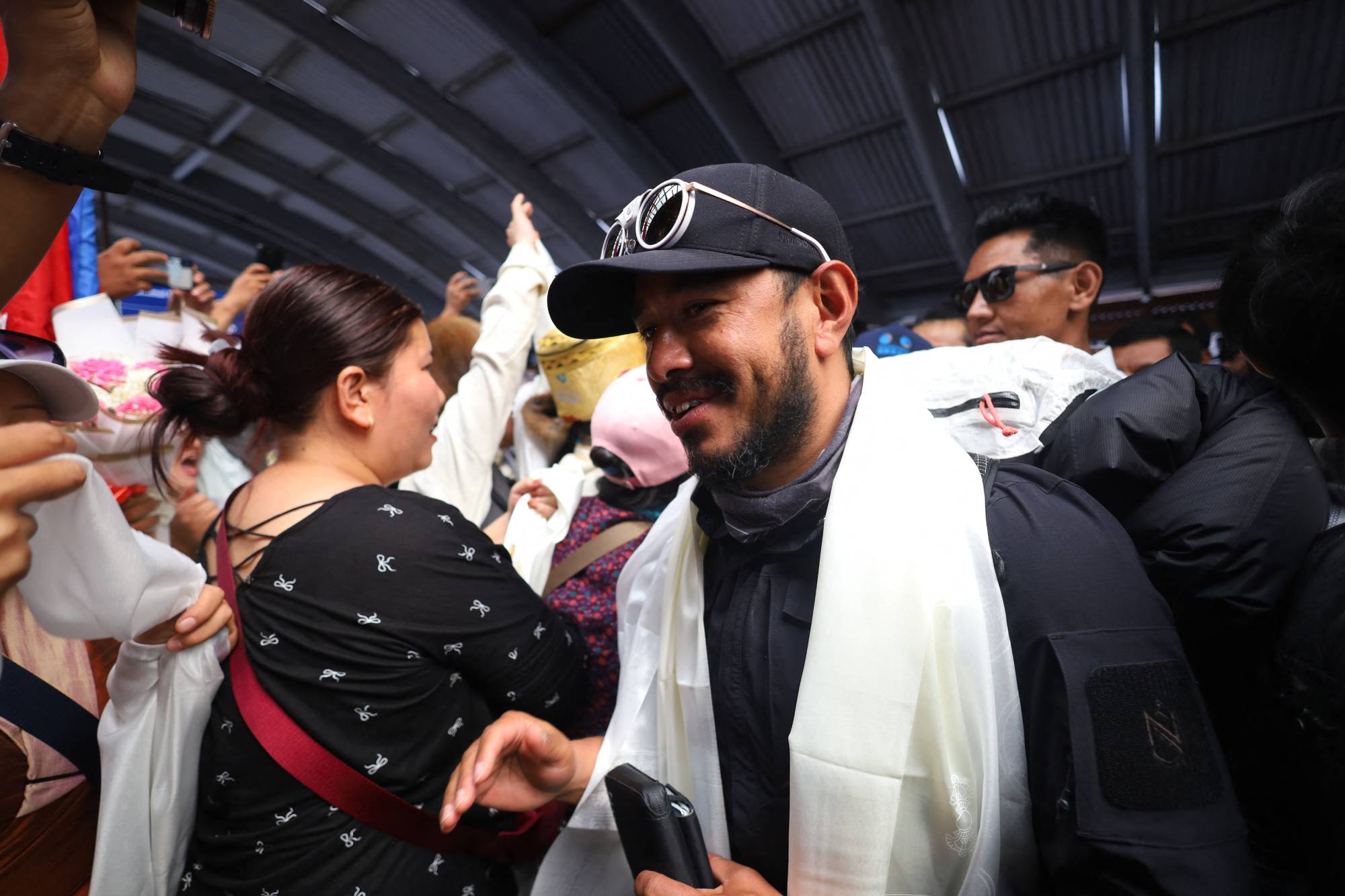 Record-setting climber Nirmal Purja, also known as Nimsdai, arrives back in Kathmandu, Nepal, on October 14, 2024, after completing the summit of 14 peaks towering above 8,000 meters without oxygen. On May 7, 2022, climber Nims begins this campaign by summiting Kanchenjunga without using supplemental oxygen. On May 27 of the same year, he ascends Everest, followed by Lhotse on May 28, Makalu, Cho Oyu, Dhaulagiri, Annapurna, Manaslu, Nanga Parbat, Gasherbrum, Broad Peak, and finally Shishapangma. Out of the 14 tallest peaks, eight are located in Nepal, while the others are in Pakistan and China. (Photo by Subaas Shrestha/NurPhoto)