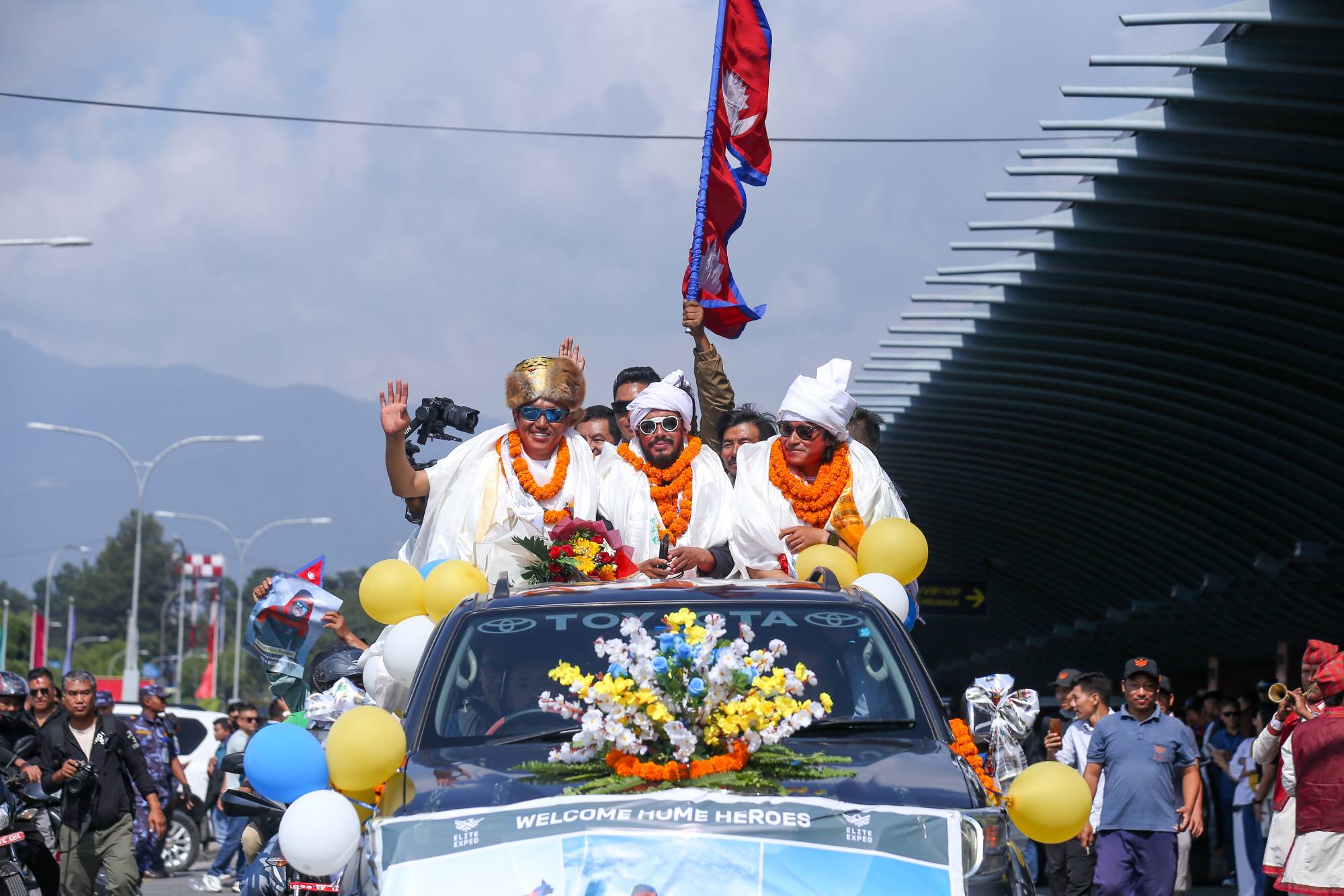 Record-setting climber Nirmal Purja, also known as Nimsdai, cheers as he arrives back in Kathmandu, Nepal, on October 14, 2024, after completing the summit of 14 peaks towering above 8,000 meters without oxygen. On May 7, 2022, climber Nims begins this campaign by summiting Kanchenjunga without using supplemental oxygen. On May 27 of the same year, he ascends Everest, followed by Lhotse on May 28, Makalu, Cho Oyu, Dhaulagiri, Annapurna, Manaslu, Nanga Parbat, Gasherbrum, Broad Peak, and finally Shishapangma. Out of the 14 tallest peaks, eight are located in Nepal, while the others are in Pakistan and China. (Photo by Subaas Shrestha/NurPhoto via Getty Images)