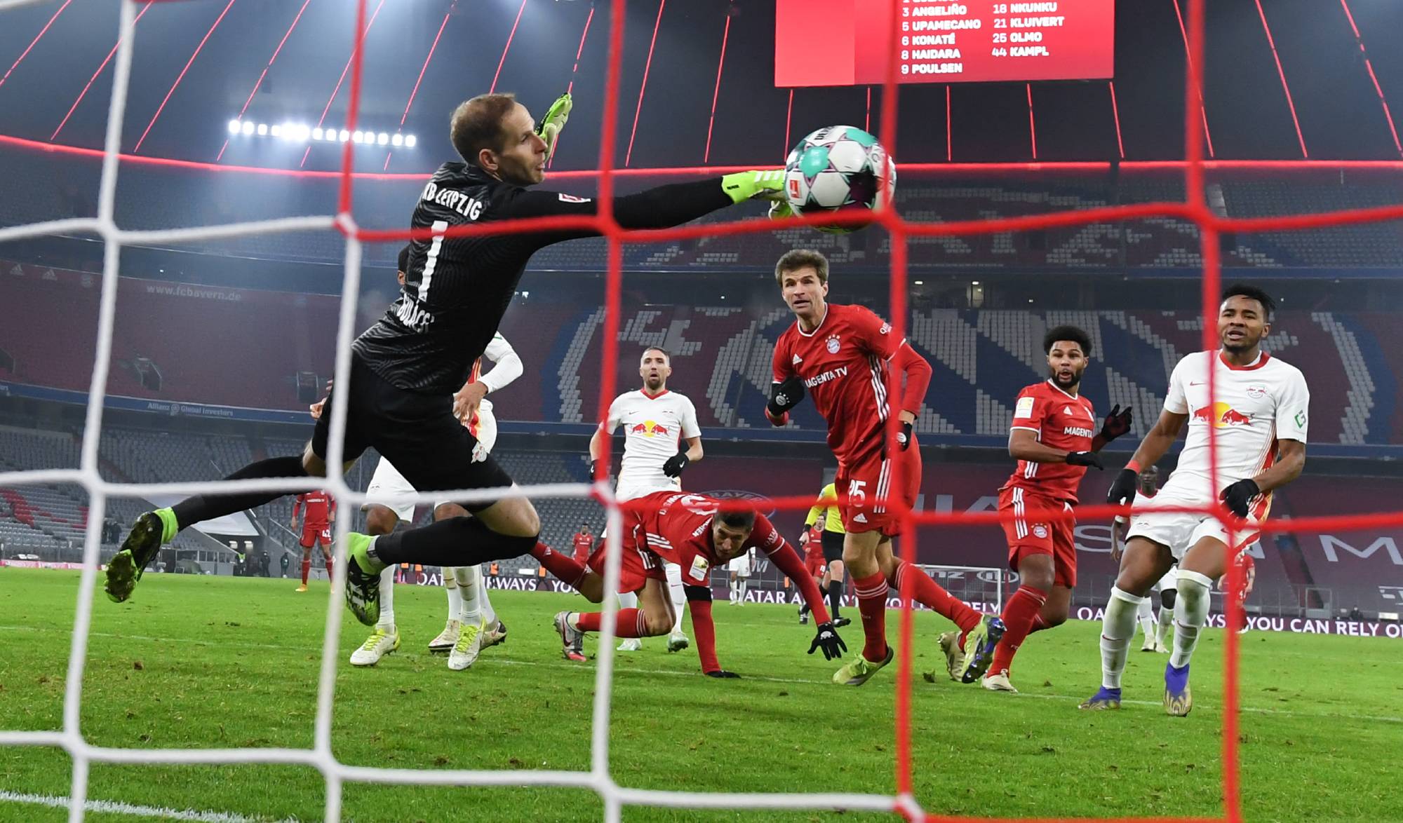 05 December 2020, Bavaria, Munich: Football: Bundesliga, FC Bayern Munich - RB Leipzig, 10th matchday in the Allianz Arena. Munich's Thomas Müller (M) scores the goal for the 3:3 against Leipzig's goalkeeper Peter Gulacsi. IMPORTANT NOTE: In accordance with the regulations of the DFL Deutsche Fußball Liga and the DFB Deutscher Fußball-Bund, it is prohibited to use or have used in the stadium and/or from the game taken photographs in the form of sequence images and/or video-like photo series Photo: Sven Hoppe/dpa