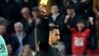 French referee Abdelatif Kherradji (R) delivers a yellow card to Nantes' French Goalkeeper #16 Anthony Lopes during the French L1 football match between Stade Rennais FC and FC Nantes at Roazhon Park stadium in Rennes, western France on April 18, 2025.