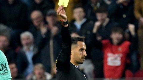 French referee Abdelatif Kherradji (R) delivers a yellow card to Nantes' French Goalkeeper #16 Anthony Lopes during the French L1 football match between Stade Rennais FC and FC Nantes at Roazhon Park stadium in Rennes, western France on April 18, 2025.