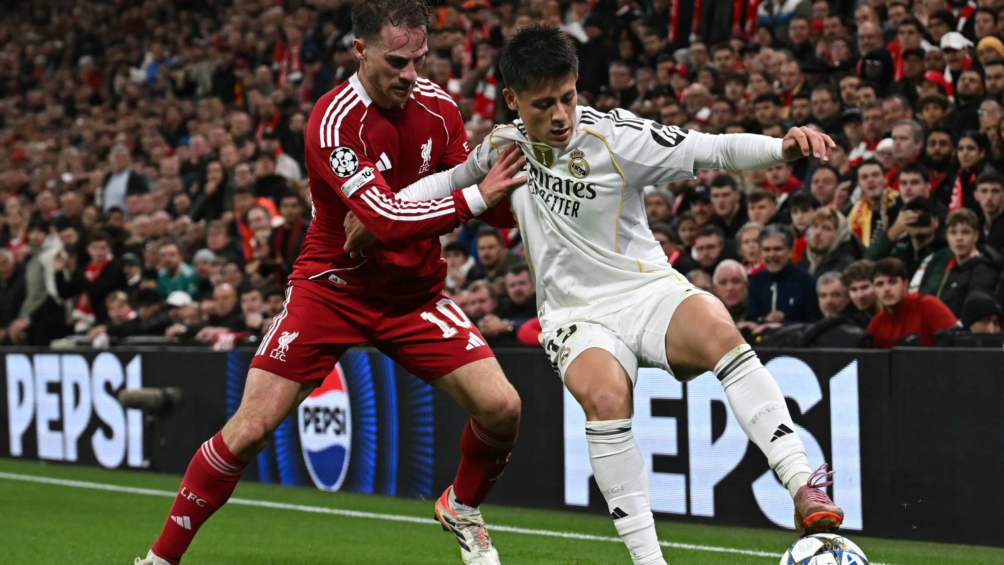 Real Madrid's Turkish midfielder #15 Arda Guler (R) vies with Liverpool's Argentinian midfielder #10 Alexis Mac Allister (L) during the UEFA Champions League, league phase football match between Liverpool and Real Madrid at Anfield in Liverpool, north west England on November 4, 2025.