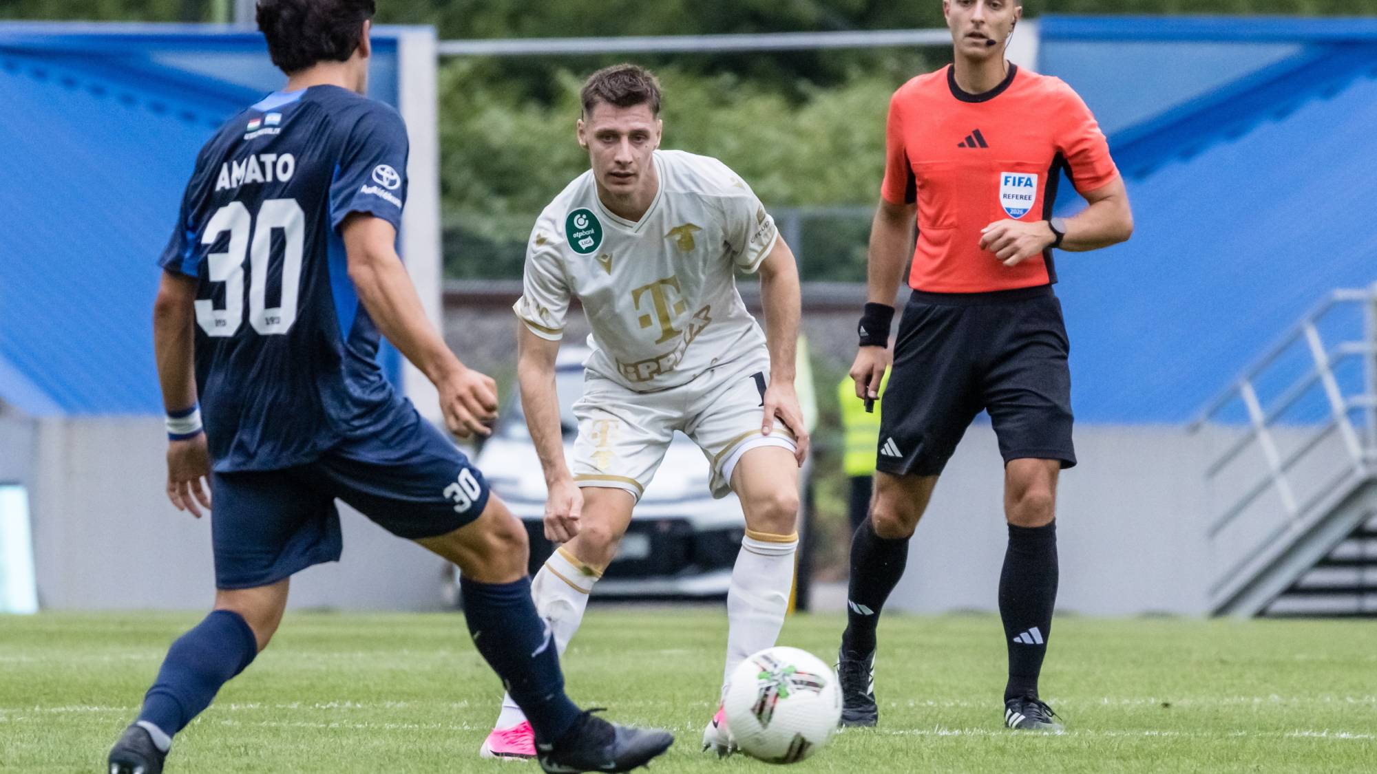 Fabricio Amato, a Zalaegerszeg (b) és Corbu Máriusz, a Ferencváros játékosa a labdarúgó OTP Bank Liga 4. fordulójában játszott Zalaegerszegi TE FC - Ferencvárosi TC mérkőzésen a zalaegerszegi ZTE Arénában 2026. augusztus 17-én. Jobbról Csonka Bence játékvezető.