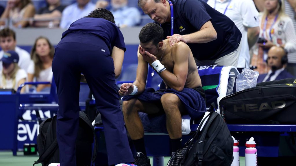 NEW YORK NEW YORK - AUGUST 30: Novak Djokovic of Serbia receives treatment from Clay Sniteman against Mariano Navone of Argentina during their Men's Singles First Round match on Day One of the 2026 US Open at USTA Billie Jean King National Tennis Center on August 30, 2026 in the Flushing neighborhood of the Queens borough of New York City. (Photo by Julian Finney/Getty Images)