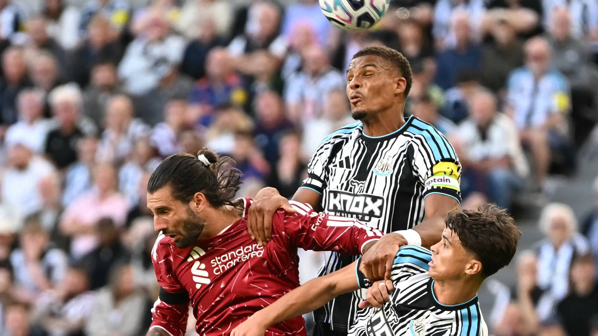 Liverpool's Hungarian midfielder #08 Dominik Szoboszlai (L) vies with Newcastle United's German defender #12 Malick Thiaw (C) and Newcastle United's English midfielder #67 Lewis Miley (R) during the English Premier League football match between Newcastle United and Liverpool at St James' Park in Newcastle-upon-Tyne, north east England on August 23, 2026.