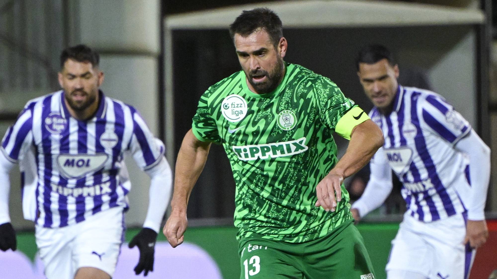 Böde Dániel (k), a Paks, mögötte Bese Barnabás (b) és Joao Nunes (k), az Újpest játékosai a labdarúgó Fizz Liga 14. fordulójában a Paksi FC - Újpest FC mérkőzésen Pakson, a Paksi FC Stadionban 2025. november 23-án. Az Újpest 3-1-re győzött.