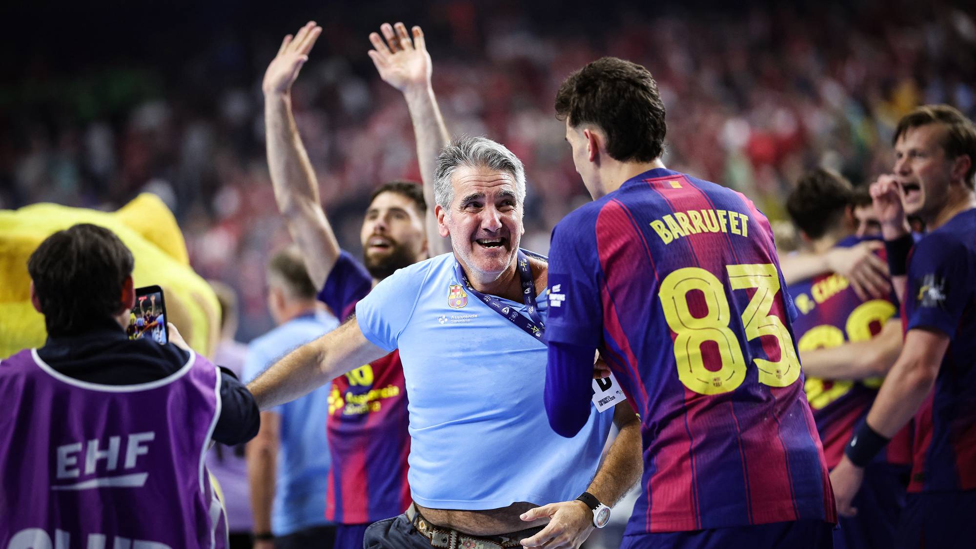 FC Barcelona's Spanish headcoach Antonio Carlos Ortega Perez (C) and his players celebrate after the EHF Men's Handball Champions League Final 4 final between Barca and Fuechse Berlin in Cologne, western Germany on June 14, 2026. Barca won the match 37:34.