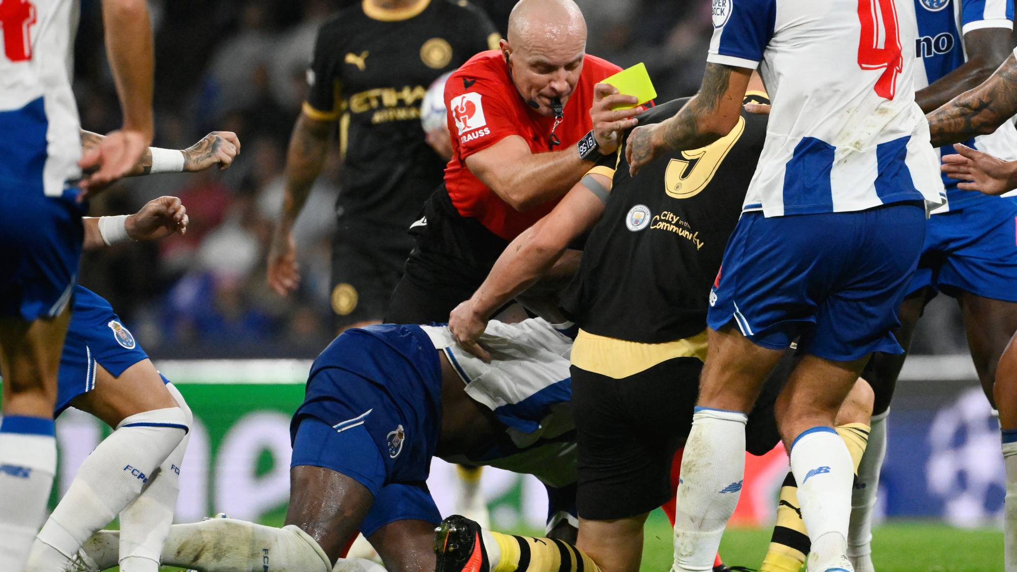 Polish referee Szymon Marciniak tries to separate Manchester City's Norwegian forward #09 Erling Haaland and FC Porto's Dominicans midfielder #13 Pablo Rosario during the UEFA Champions League first round day 1 football match between FC Porto and Manchester City at Dragao stadium in Porto on September 8, 2026.