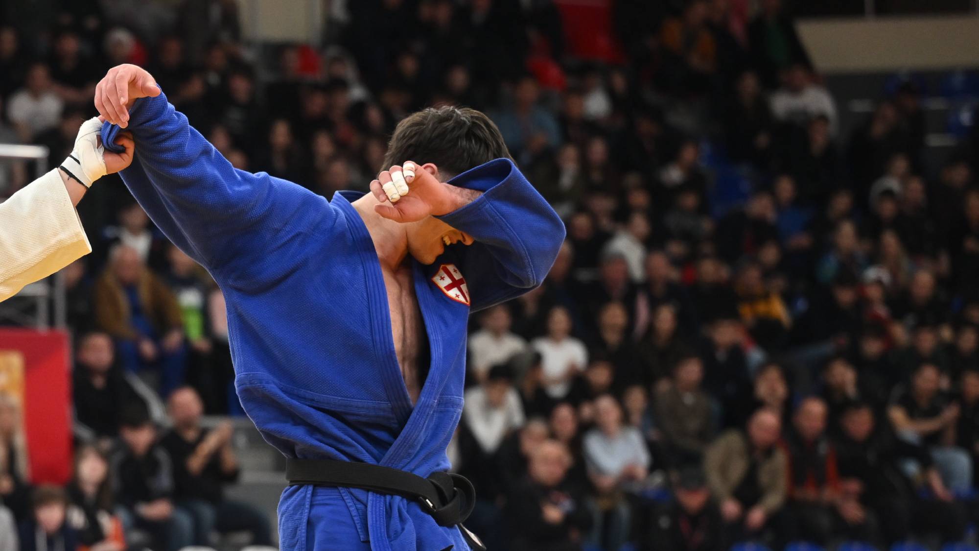 TBILISI, GEORGIA - MARCH 22: Luka Javakhishvili of Georgia (white) reacts after defeating Akaki Japaridze of Georgia (blue) in the Men's -90kg bronze medal contest during Tbilisi Grand Slam 2026 at New Sports Palace on March 22, 2026 in Tbilisi, Georgia. (Photo by Levan Verdzeuli/Getty Images)