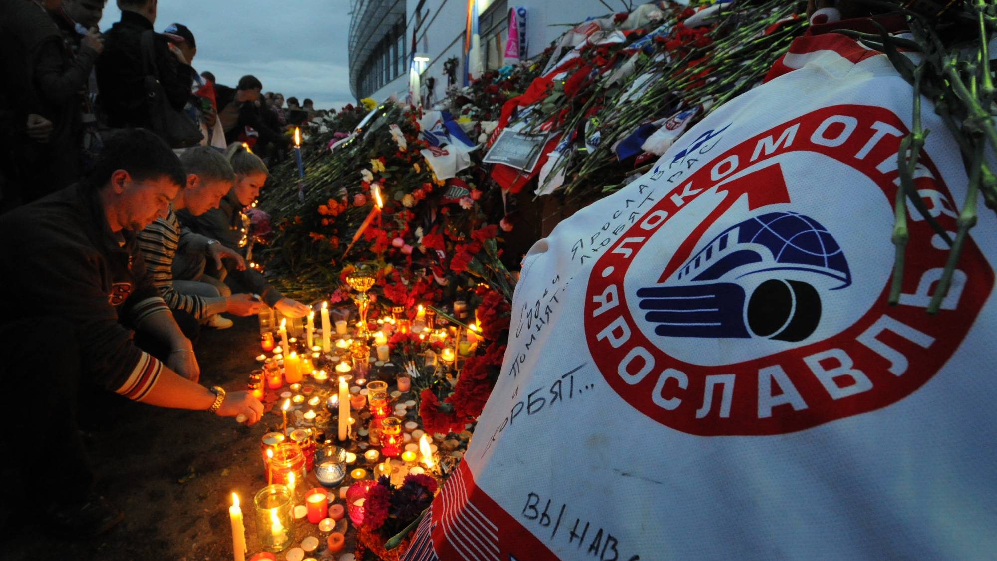 People lay flowers in front of the Arena-2000, the home venue of the Lokomotiv Yaroslav team, in Yaroslavl, on September 8, 2011, in honor of the members of the team who were among the 43 people killed in a plane crash on September 7. AFP PHOTO/ ALEXANDER NEMENOV