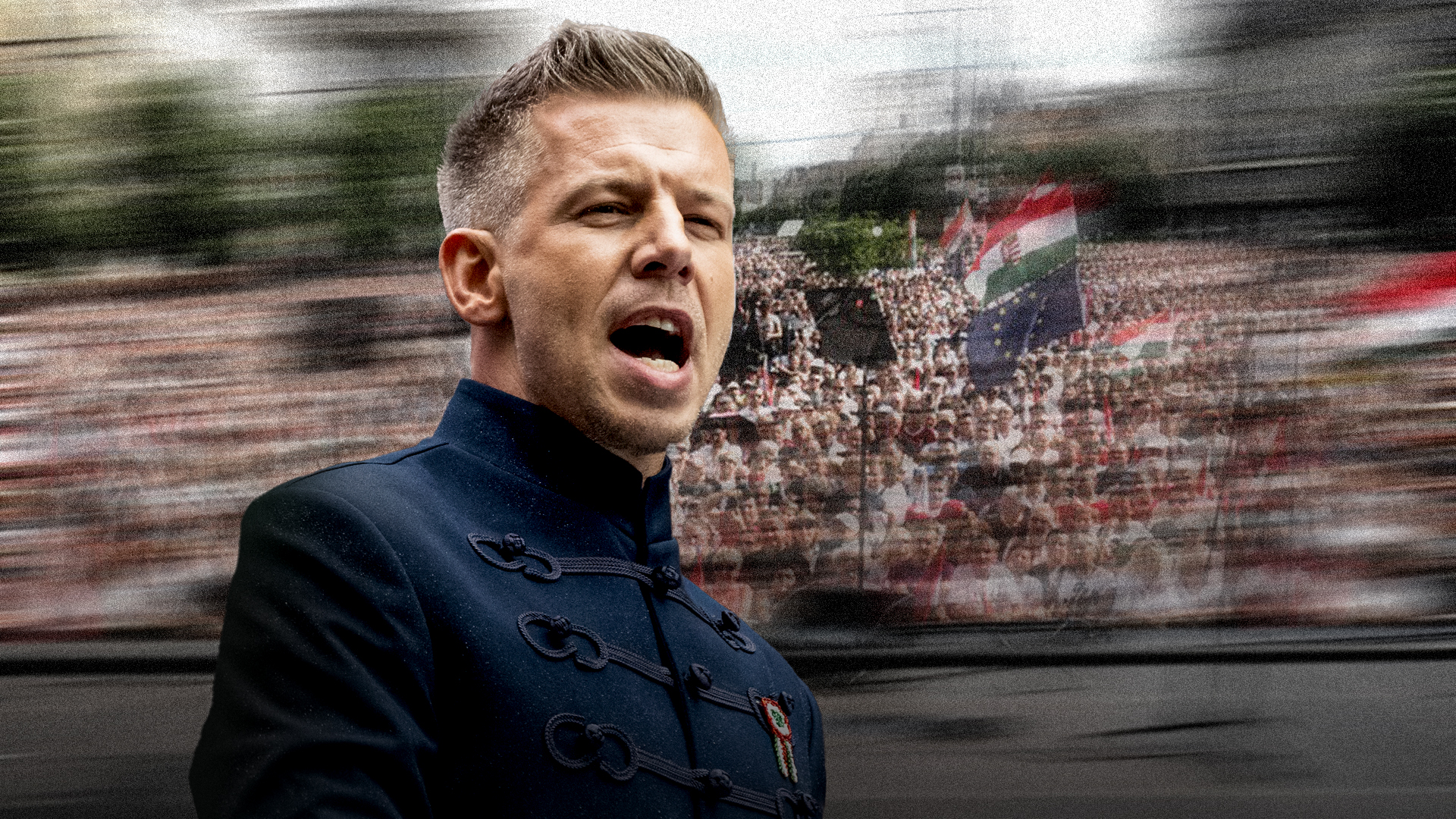 Close-up of a man in a navy, military-style coat speaking to a cheering crowd at a rally, with motion blur behind him.