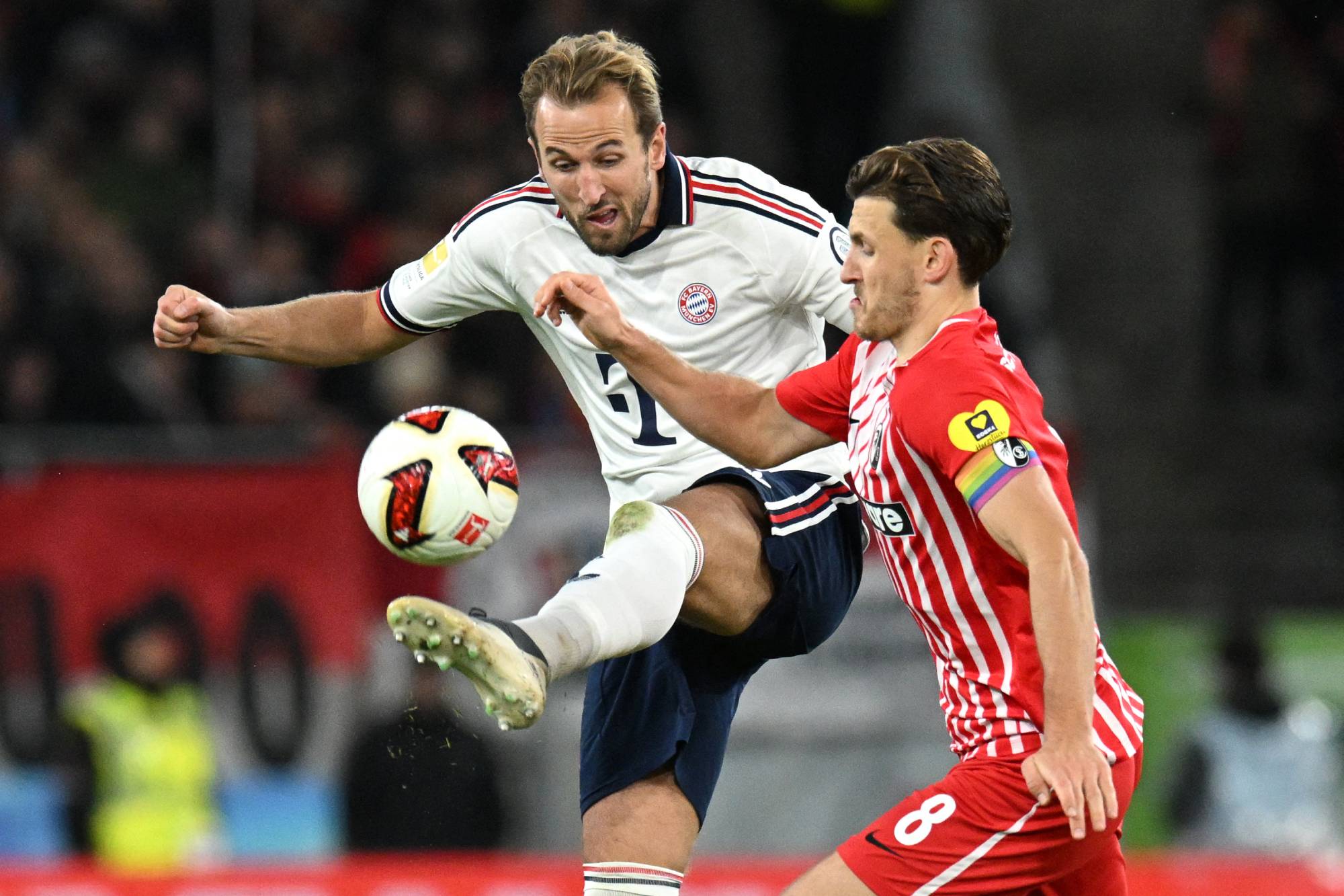 Bayern Munich's English forward #09 Harry Kane (L) and Freiburg's German midfielder #08 Maximilian Eggestein vie for the ball during the German first division Bundesliga football match between SC Freiburg and FC Bayern Munich in Freiburg, south-western Germany, on October 25, 2026.