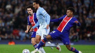 Manchester City's French born Moroccan midfielder #32 Ayyoub Bouaddi (C) is tackled by Paris Saint-Germain's French midfielder #14 Desire Doue (R) during the UEFA Champions League, league phase football match between Manchester City and Paris Saint Germain at the Etihad Stadium in Manchester, north west England, on October 14, 2026.