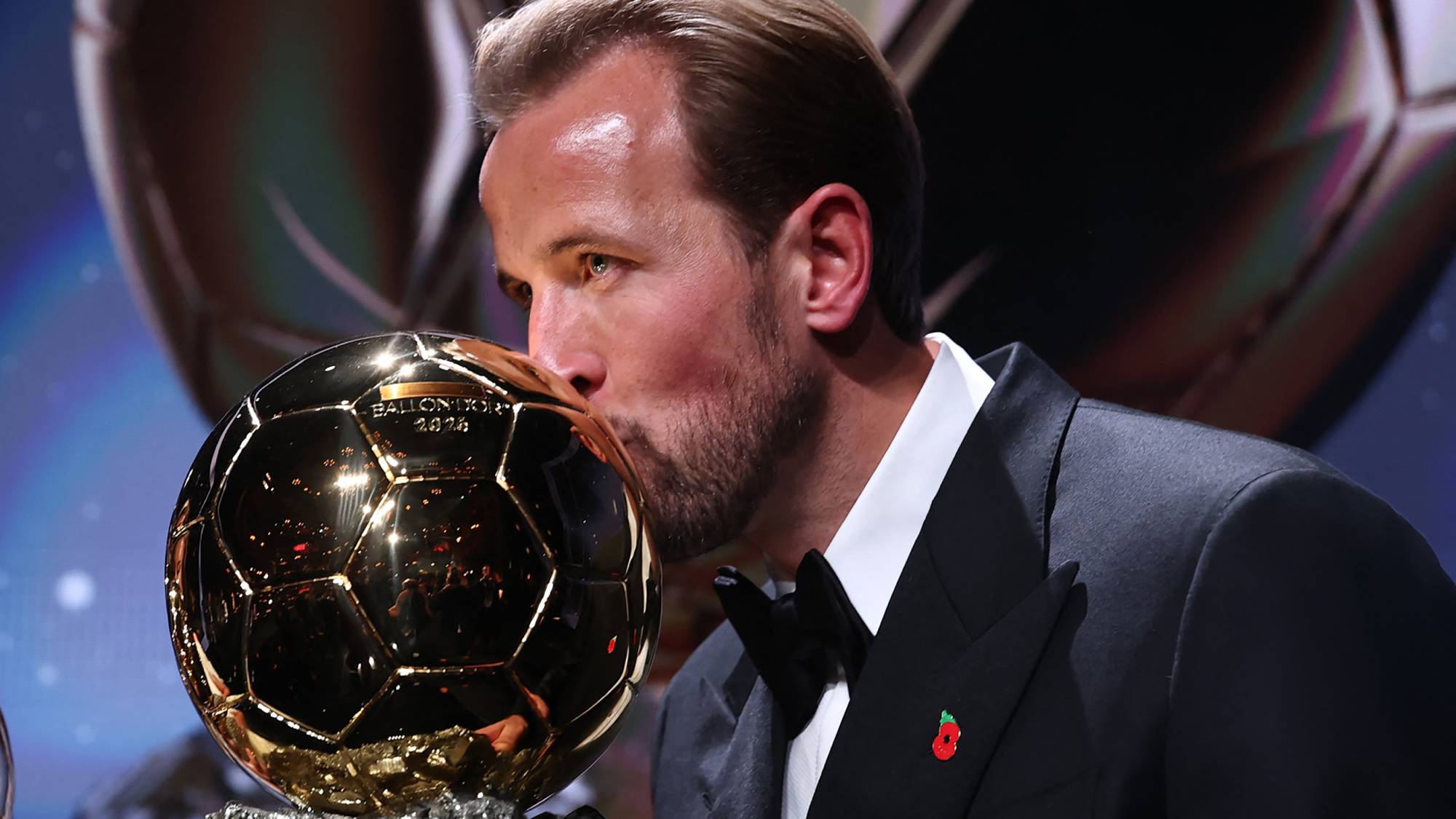 England and Bayern Munich forward Harry Kane kisses the trophy on stage after receiving the Ballon d'Or award for the best male footballer during the 2026 Ballon d'Or France Football award ceremony at the Palladium Theatre in London on October 26, 2026.