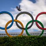 A crow flies above the Olympics Rings displayed at the headquarters of the International Olympic Committee (IOC) in Lausanne on May 13, 2026.