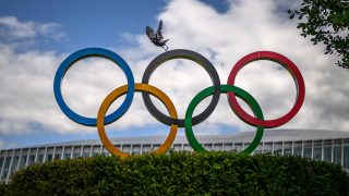 A crow flies above the Olympics Rings displayed at the headquarters of the International Olympic Committee (IOC) in Lausanne on May 13, 2026.