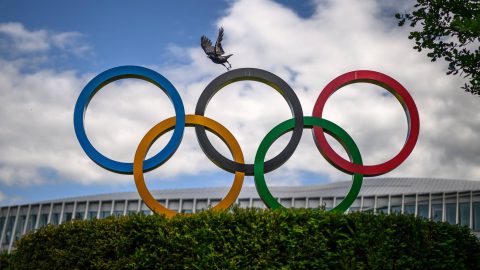 A crow flies above the Olympics Rings displayed at the headquarters of the International Olympic Committee (IOC) in Lausanne on May 13, 2026.