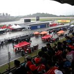 Teams gather around the cars as the start of the race has been delayed due to heave rain at the Formula One Bahrain Grand Prix in Sepang on October 4, 2026.