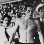 (Original Caption) Melbourne: Injured In Water Polo Brawl... Hungarian Ervin Zador with blood pouring from a cut eye is led to a casualty room for attention for the injury which he received from a Russian player in the closing stages of the Hungary VS Russia water polo match today. The game ended in chaos with hundreds of new Australians in the crowd screaming for the blood of the Russians. Throughout the match which Hungary won 4-0 fists, elbows, knees and feet were used when the players came in contact.
