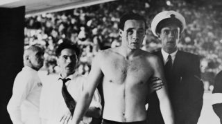 (Original Caption) Melbourne: Injured In Water Polo Brawl... Hungarian Ervin Zador with blood pouring from a cut eye is led to a casualty room for attention for the injury which he received from a Russian player in the closing stages of the Hungary VS Russia water polo match today. The game ended in chaos with hundreds of new Australians in the crowd screaming for the blood of the Russians. Throughout the match which Hungary won 4-0 fists, elbows, knees and feet were used when the players came in contact.